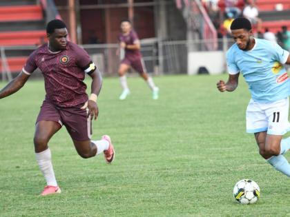 Waterhouse’s Rohan Brown (right) tries to dribble past Chapelton Maroons’ Donhue Mitchell during a Jamaica Premier League football game at the Anthony Spaulding Sports Complex yesterday. 
