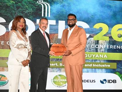 Guyana President Dr Mohamed Irfaan Ali (right) accepts a gift from new Chairman of the Caribbean Tourism Organization, Antigua and Barbuda’s Minister of Tourism, Charles Fernandez, while Secretary General and CEO of the CTO, Dona Regis-Prosper shares in 