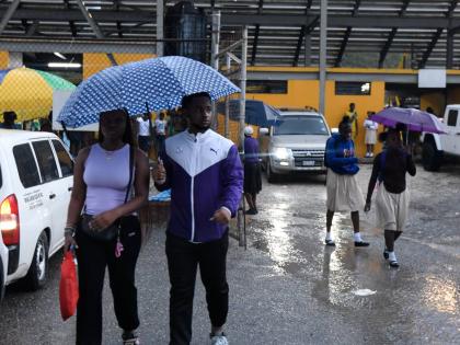Kingston College supporters leave the Stadium East yesterday after the opening Walker Cup KO semi-final between Excelsior High and Kingston College was halted by heavy rain at the venue. 