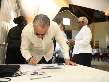 President of the Senate Tom Tavares Finson signs the condolence book for late veteran journalist Balford Henry