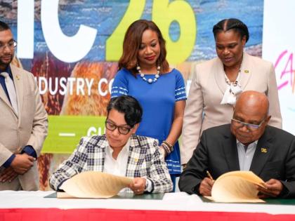 Minister of Tourism Edmund Bartlett (right, seated) and Guyana’s Minister of Tourism Susan Rodrigues (left, seated) beam as they sign a special MOU last Friday.