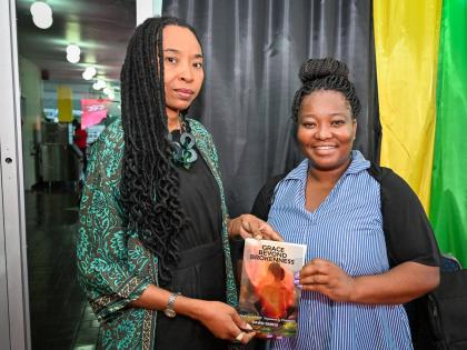 Senior Director at the National Gallery of Jamaica Dr Nadine Boothe-Gooden (left) joins author and philanthropist Dawn Smikle in displaying her book titled ‘Grace Beyond Brokenness ‘, during Sunday’s  Legal Deposit Day Celebration at the Ministry of 
