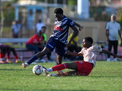 Shaquille Lindo (right) of Mona High School  puts in a firm tackle on Gerveir Grant of Jamaica College during the Walker Cup semi-final match between Jamaica College and Mona High School held on October 10, 2026 at the Stadium East field. 
