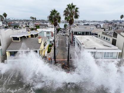 Waves hit a walkway in front of homes in Long Beach, California, Saturday, October 10, 2026, as Tropical Storm Rachel approaches. (AP Photo/William Liang)