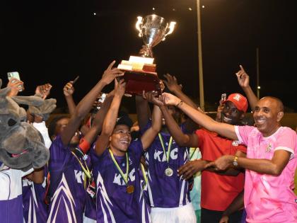 Keith Wellington (right), President of the Inter-Secondary Schools Association and Andrei Roper (second right) Marketing Manager, Restaurants of Jamaica, present the Walker Cup to the 2026 champions, Kingston College, shortly after they defeated Mona High 