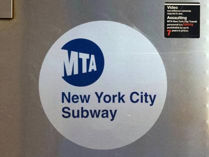 FILE - The MTA logo is seen on the side of a New York City subway car, April 23, 2020, in New York. (AP Photo/Mark Lennihan, File)