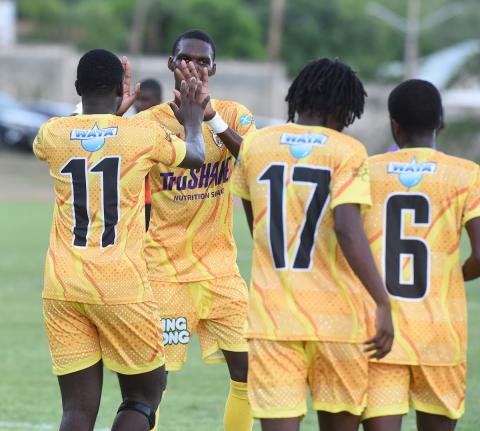 Members of Garvey Maceo High’s daCosta Cup football team celebrate after scoring against Foga Road High on the opening day of the competition at the Stadium East field last Saturday.
