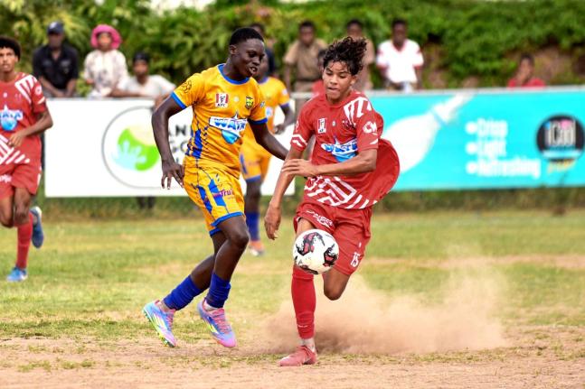 Luke Stanley (right) of Campion College tries to dribble by Streme Cha of Papine High School during their ISSA/WATA Manning Cup football match at Campion College in St Andrew yesterday. Campion won 1-0.