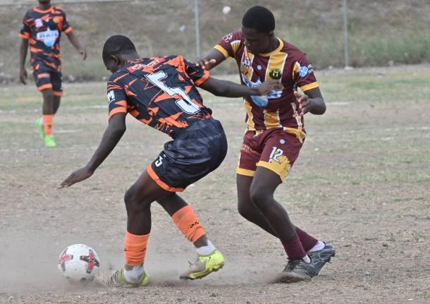 Jeremy Forbes (left) of Tivoli High shields the ball from Denham Town High’s Roger Morgan during a Manning Cup match at St Andrew Technical High School on Wednesday, September 10. Tivoli won 7-0.