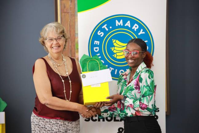 Ernest Johnston Memorial Bursary (EJMB) recipient, Nevena Jones (right), receives a congratulatory token from Patricia Francis, representing the EJMB at the 2025  St Mary Education Trust Awards Ceremony.