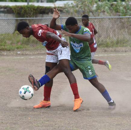 Antonio Fearon (left) of Eltham High shields the ball from Norman Manley High’s Nickoy Davidson during their Manning Cup football match at Norman Manley yesterday. The game was abandoned after 64 minutes due to heavy rain and lightning, with Eltham leadi