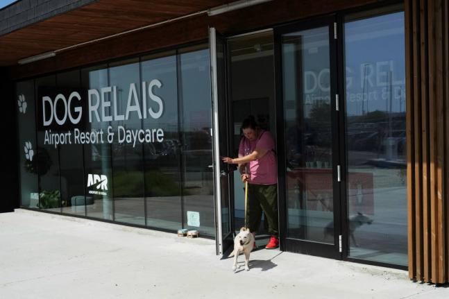A costumer walks with her dog as she leaves the Dog Relais, a hotel for dogs at Rome’s Fiumicino International Airport.
