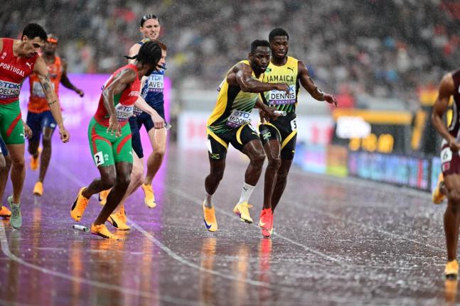 Jamaica’s Jashauna Dennis (right) hands over to Rusheen McDonald (second right) during the men’s 4x400-metre final at the World Athletics Championships in Tokyo, Japan, yesterday.  Jamaica finished seventh in 3:03.46.