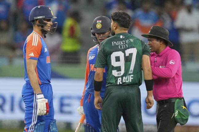 The umpire (right) mediates between Indian players Abhishek Sharma (left) and Shubman Gill and Pakistan’s Haris Rauf (second right) during the Asia Cup cricket match between India and Pakistan in Dubai yesterday.