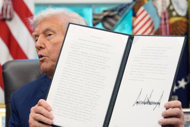 President Donald Trump holds a signed executive order regarding TikTok in the Oval Office at the White House, Thursday, September 25, 2025, in Washington. (AP Photo/Alex Brandon)