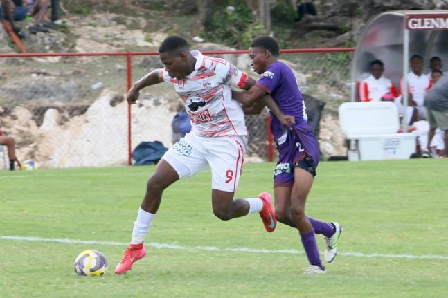 Orane Watson (left) of Glenmuir High powers past Bustamante High’s Omario Brissettt in a daCosta Cup match on September 10.  
Hosts Glenmuir won 13-0 with Watson scoring eight times. 