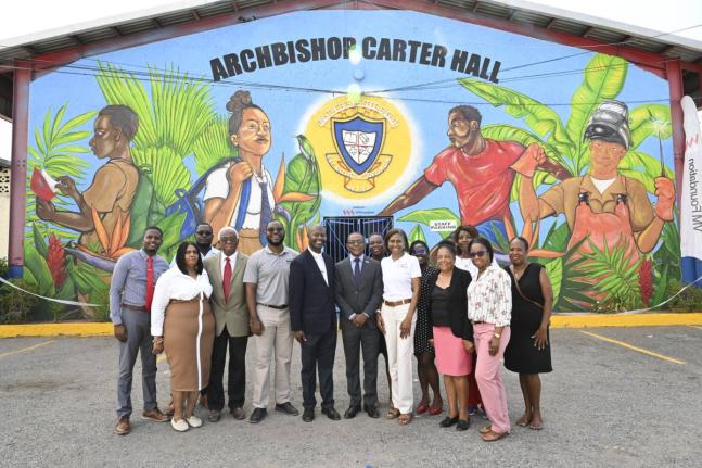 Samantha Charles (third right), CEO of the VM Foundation, leads members of the VM team and the Holy Trinity High School faculty in a photo opportunity following the official handover of a legacy mural (in the background) to the school on September 16. It i