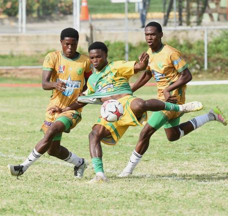 Excelsior High School’s Kimarly Scott (centre) has his shirt tugged by St Jago’s Jordon Taylor while attempting to kick during their ISSA/WATA Manning Cup football Game at the Courtney Walsh Oval yesterday. That game ended 0-0.