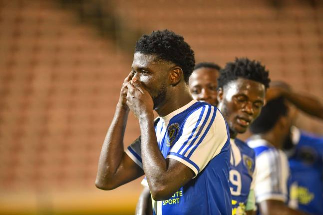 Mount Pleasant’s Ranaldo Biggs celebrates with teammates after scoring against Universidad O&M during their final Concacaf Caribbean Cup group match at the National Stadium on September 30.