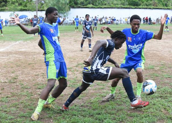  Jamaica College’s Duwayne Burgher (centre) attempts to dribble  past Serani Brown (left) and Antoinne Burton of  Vauxhall High during their Manning Cup football match at Vauxhall yesterday. The game ended in a 1-1 draw.