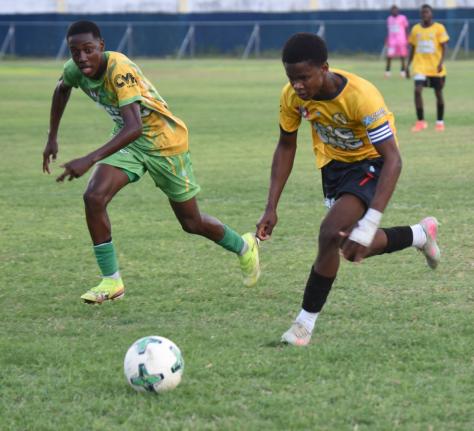 York Castle High School’s Chadoye Higgins (right) tries to outrun Ocho Rios High School’s Ryan Francis during their ISSA daCosta Cup Zone K match at the Drax Hall Sports Complex yesterday.