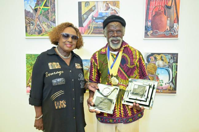 Minister of Culture, Gender, Entertainment and Sport Olivia Grange (left) and Most Outstanding Overall Artist, Nugent Hewitt, 72, who received six gold medals and one silver medal in the 2025 Jamaica Cultural Development Commission Visual Arts Competition.