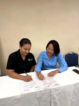 Danellia Aitcheson (left), manager of the National Conservation Trust Fund of Jamaica, and Tanja Lieuw, Conservation Finance Programme Manager at the Caribbean Biodiversity Fund, affix their signatures to the partnership document.