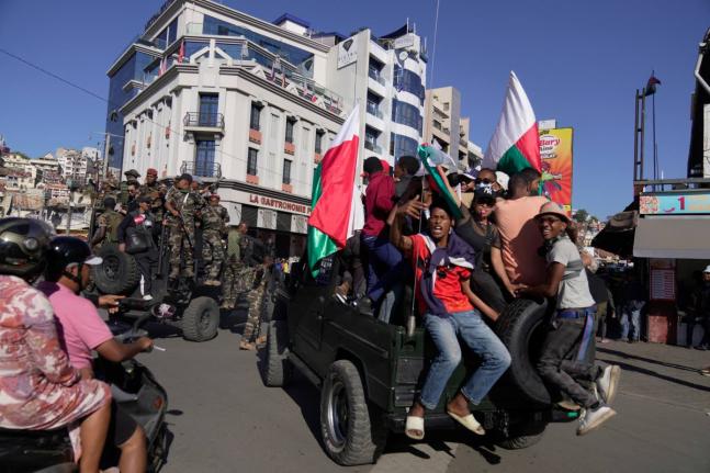 Troops loyal to CAPSAT military unit commander Col. Michael Randrianirina make their way to the presidency to announce that the armed forces are taking control of the country in Antananarivo, Madagascar, Tuesday, October14, 2025. (AP Photo/ Brian Inganga)