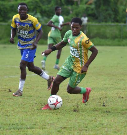 Ocho Rios High’s Nathan Whitehorne (right) dribbles away from Rusea’s High’s Omarion Jemmison during their Group 2 ISSA daCosta Cup football match at the Collin Miller Sports Complex  yesterday. Ocho Rios won 3-1.