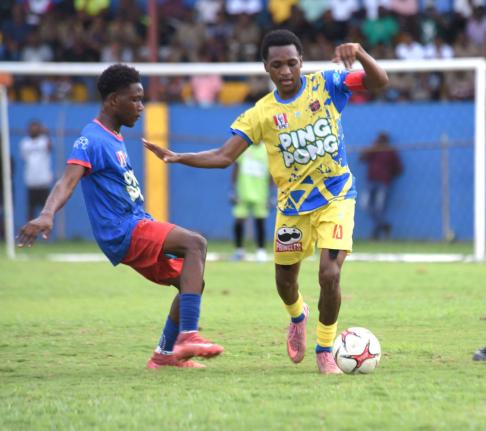 St Elizabeth Technical High School’s (STETHS) Deandre Barnett (right) tries to evade the challenge of Kemps Hill High School’s Rcardo Dea during their ISSA daCosta Cup round-of-16-clash at the STETHS Sports Complex yesterday.