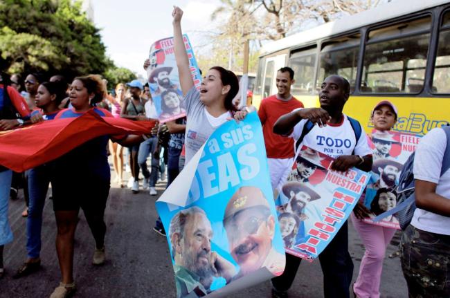 In this 2009 photo students are seen holding posters of Raul Castro and Fidel Castro, and chanting slogans during a march to mark the 48th anniversary of the triumph of Cuban forces during the 1961 Bay of Pigs invasion, in Havana.