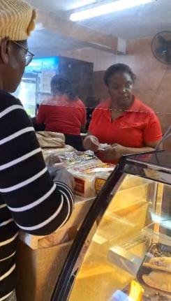 A customer buying baked goods at Top Loaf Bake Shops in Mandeville, Manchester on October 27, 2025, as Hurricane Melissa nears.