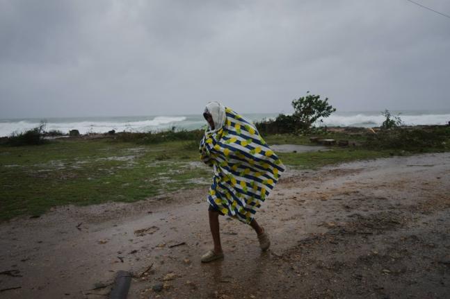 A man walks in the rain before the arrival of Hurricane Melissa in Canizo, a village in Santiago de Cuba, Tuesday, October 28, 2025. (AP Photo/Ramón Espinosa)