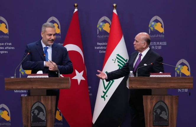 Turkish Foreign Minister Hakan Fidan (left) listens to his Iraqi counterpart Fuad Hussein during a news conference after a meeting at the foreign ministry in Baghdad, Iraq.