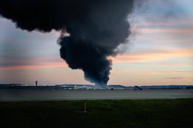 A plume of smoke rises from the site of a UPS cargo plane crash at Louisville Muhammad Ali International Airport on Tuesday, November 4, 2025, in Louisville, Ky. (AP Photo/Jon Cherry)