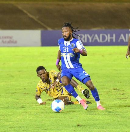 Mount Pleasant Football Academy’s Demario Phillips dribbles away from Defence Force’s Kaihim Thomas during their Concacaf Caribbean Cup football match at the National Stadium in Kingston last night. Defence Force of Trinidad and Tobago won 1-0. Mount P