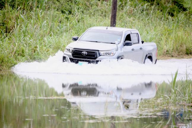 A driver crosses the flooded roadway in Content, Williamsfield, Manchester, where rising underground water has flooded several houses and the roadway making it impassable.