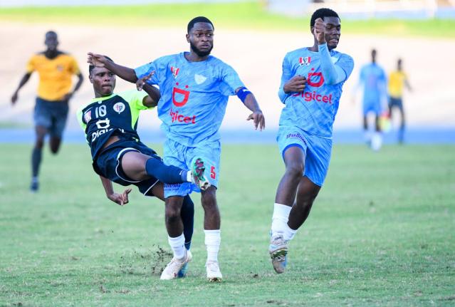 Giovanni Taylor (left) of Jamaica College attempts a shot at goal as Romaine Walters (centre) and Tchane Riley (right) of St Catherine High  try to stop him. The action is from the Jamaica College versus St Catherine High Manning Cup semi-final played at t