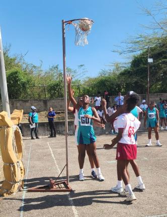 Denbigh High goal defence Cheyenne Mills (left) looks on as Kemps Hill High goal shooter Ashanne Gallimore (right) sinks one of six goals for her team in Thursday’s ISSA rural schoolgirls under-19 match at Denbigh. Denbigh defeated their opponents 68-6.