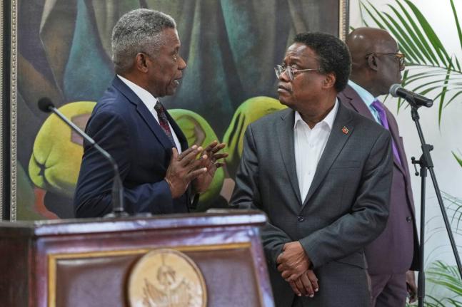 Chief of Protocol of the National Palace Marc Marie Yves Mazile speaks to Fritz Alphonse Jean, a member of Haiti’s transitional presidential council, before the start of a press conference in Port-au-Prince, Haiti on November 25, 2025. 