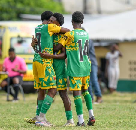 Excelsior High’s Terrence Williams (left) and Demario Whyte (right) hug teammate Kimarly Scott after his brilliant goal against Tivoli High in a Manning Cup second-round match at the Excelsior playing field on Tuesday. Excelsior won 3-2.