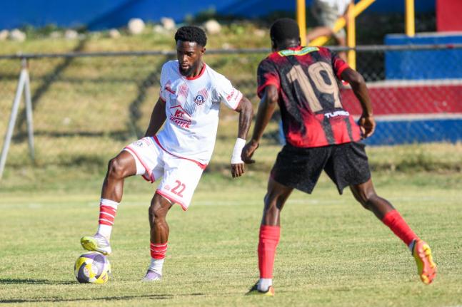 Ronaldo Robinson (left) of Portmore United tries to go around Dexter Manning of Arnett Gardens during their Jamaica Premier League match at Ferdi Neita Park yesterday.