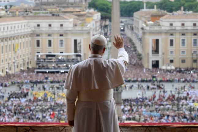 Pope Leo XIV waives from the central balcony of St. Peter's Basilica overlooking St. Peter's Square where tens of thousands of faithful gathered at noon to receive the first traditional Sunday blessing after his election and to pray the Regina Caeli.