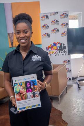 Co-founder and Executive Director of Kingston Creative and Co-chair of the Cultural and Creative Industries Alliance of Jamaica, Andrea Dempster Chung, holds up a copy of the 2025 Cultural and Creative Industries Alliance of Jamaica Survey Report, at its r