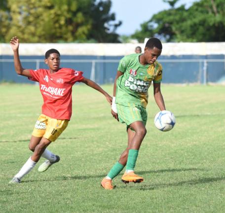 Ocho Rios High’s Dario James (right) turns away from Dimell White of Old Harbour High  during their ISSA Ben Francis KO round one match at Drax Hall Sports Complex yesterday.