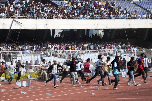 Indian fans vandalise stadium chairs as they run on to the field after failing to get a glimpse of Argentine soccer star Lionel Messi at the Salt Lake Stadium, in Kolkata, India, Saturday, December 13, 2025. (AP Photo/Bikas Das)