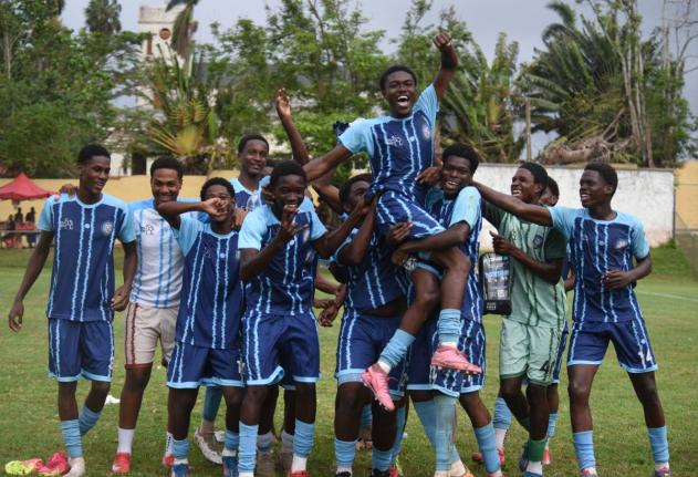 Manning’s School players hold substitute player Jordan Turner aloft in celebration of the part he played in a 2-1 victory over Christiana High in the ISSA Ben Francis Cup quarter-final football game at the Manchester High playing field yesterday.