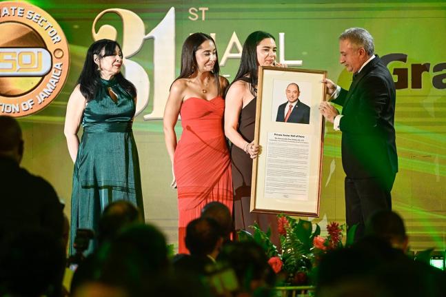 Daughters of the late Don Wehby, Stephanie (second left) and Abigail, accept a plaque from President, Private Sector Organisation of Jamaica, Metry Seaga, inducting Wehby in the PSOJ 31st Hall of Fame on Monday. Sharing in the moment is Wehby’s sister, D