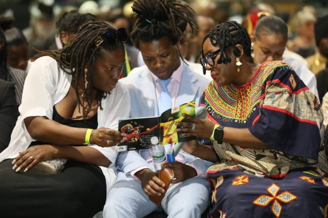 Some of Jimmy Chambers Cliff’s children, son Romeo Cliff and daughters Kadijah Cliff (left) and Odessa Chambers, take part in the music legend’s official funeral held yesterday at the National Indoors Sports Centre in Kingston.