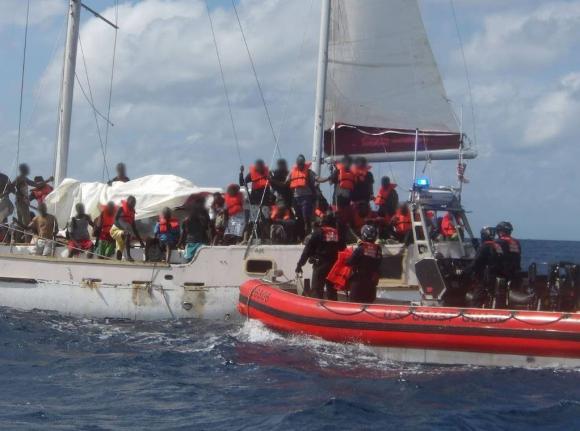 In this February photo provided by the US Coast Guard shows overloaded boat with scores of Haitian migrants being intercepted. 